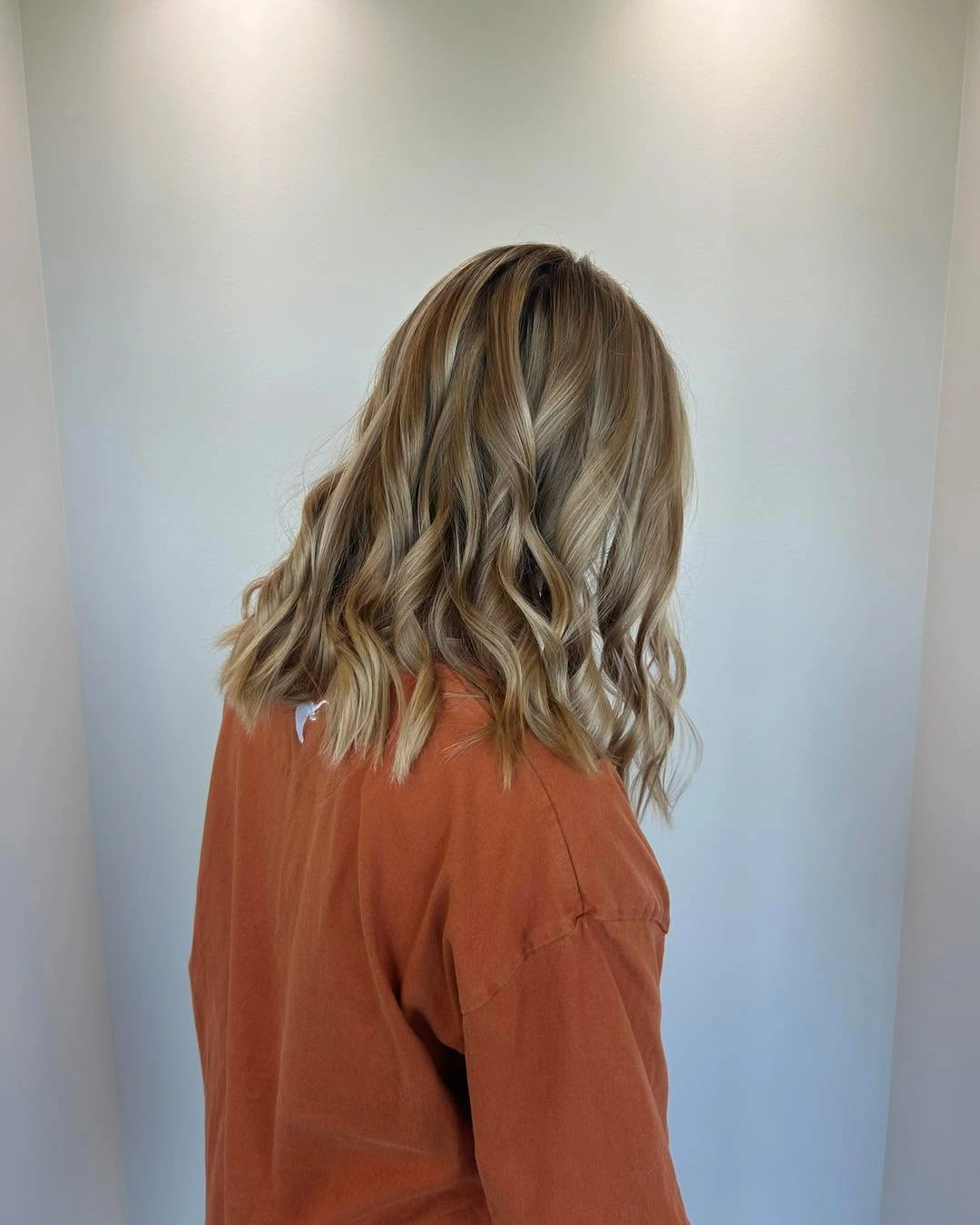 Shoulder-length blonde and light brown hair with defined waves