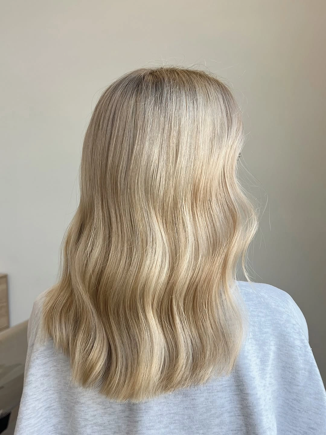Shoulder-length light blonde hair with broad waves and even lower edge