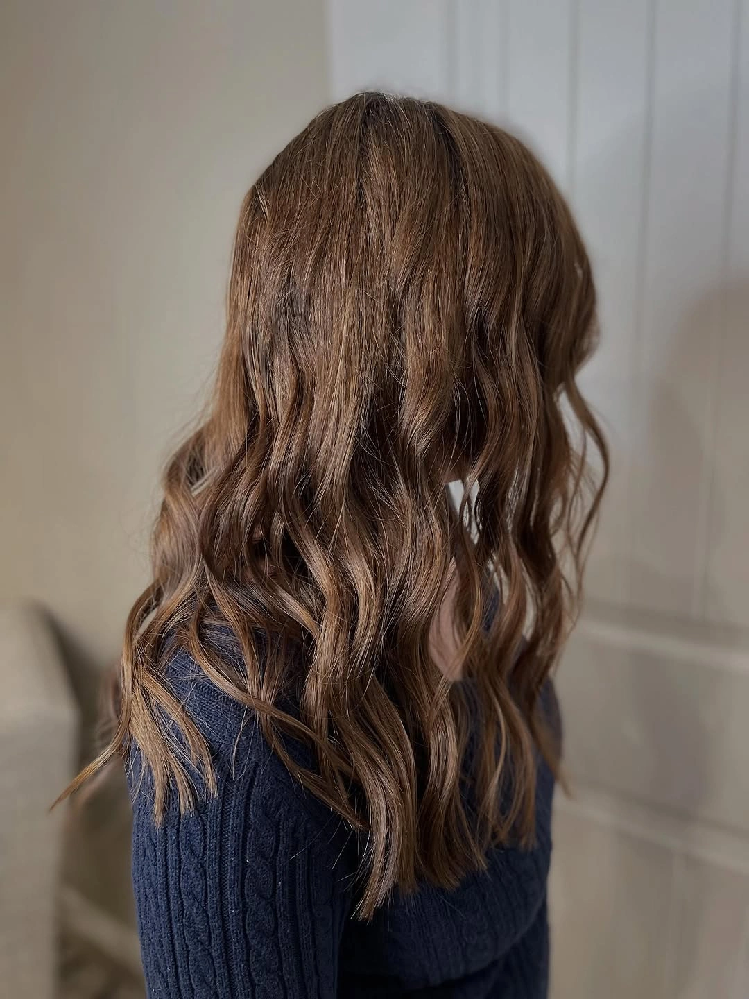 Medium-long brown hair with loose waves and tapered lower pieces