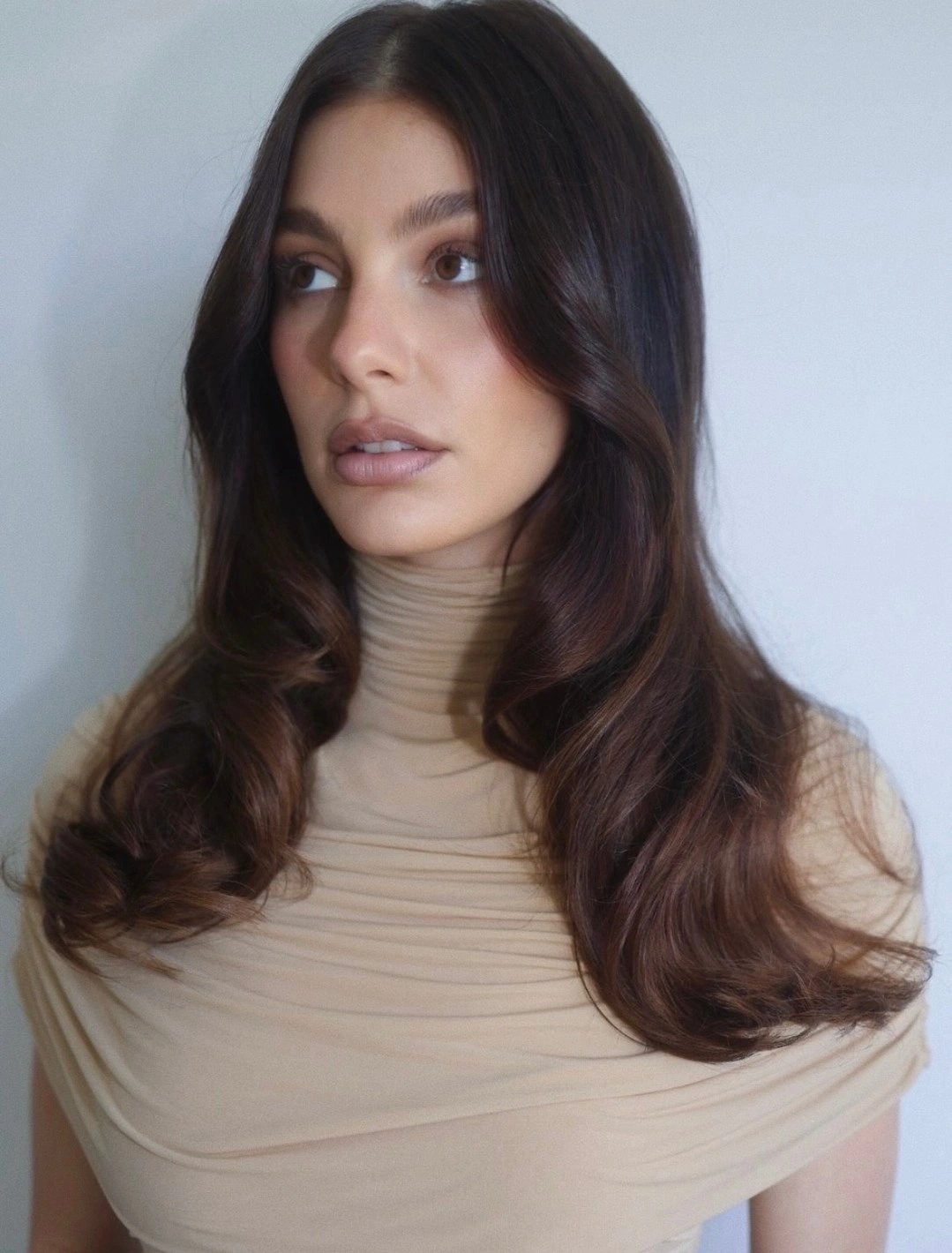 Long dark brunette hair with center part and curved front layers