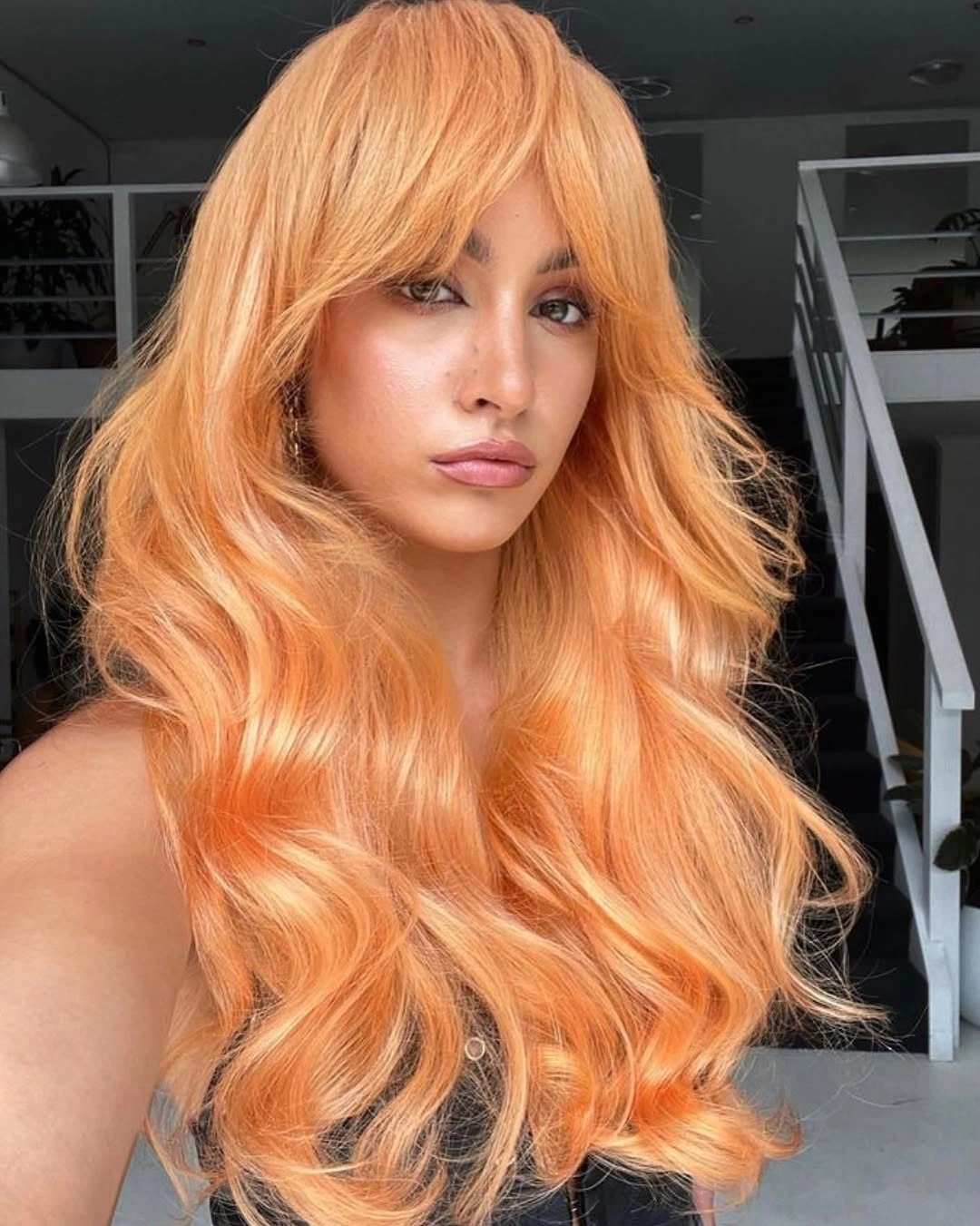 Very long peach-orange hair with full bangs and large waves