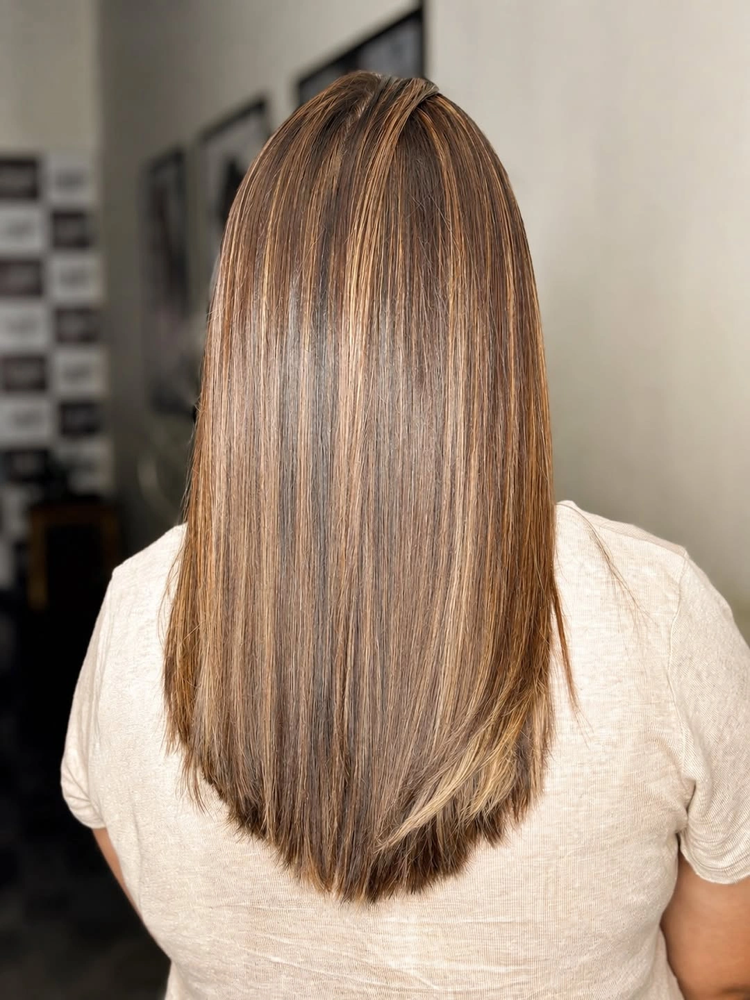 Long straight brown hair with lighter sections and full lower perimeter