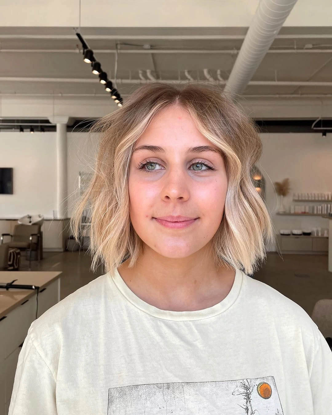 Short blonde bob with center part and softly textured ends