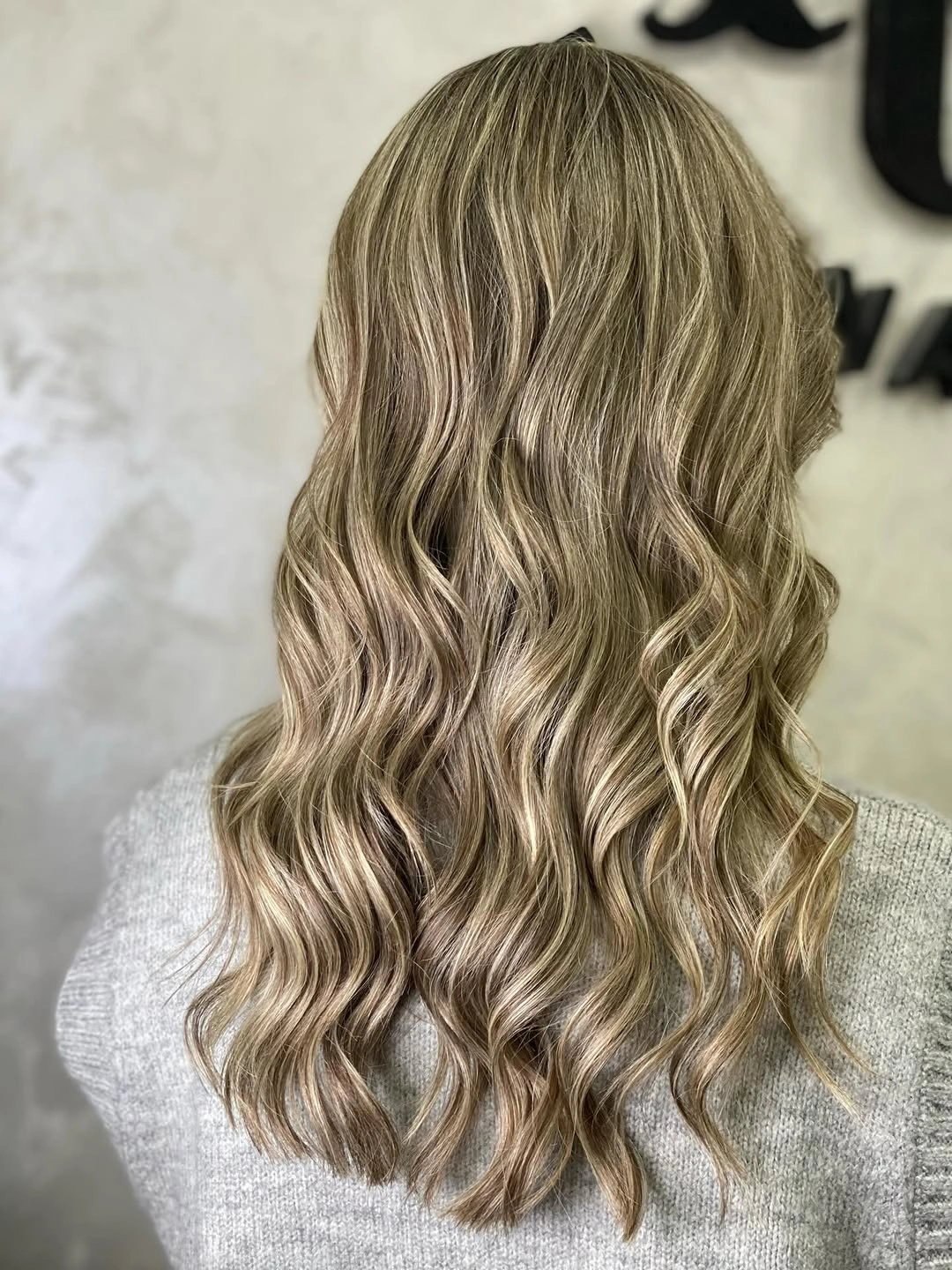 Long ash blonde brown waves shown from the back