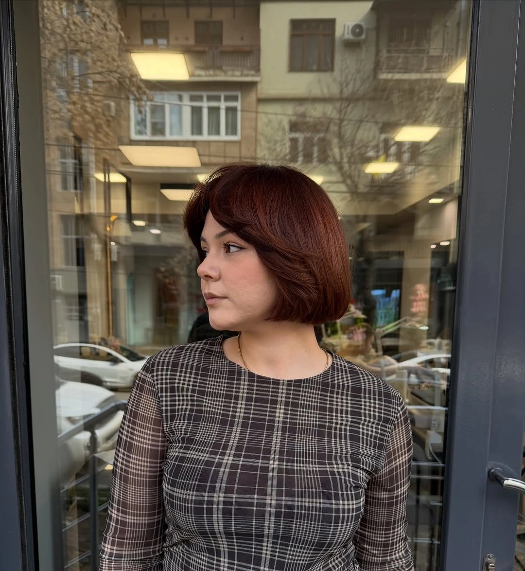Short red brown bob with side part and curved ends