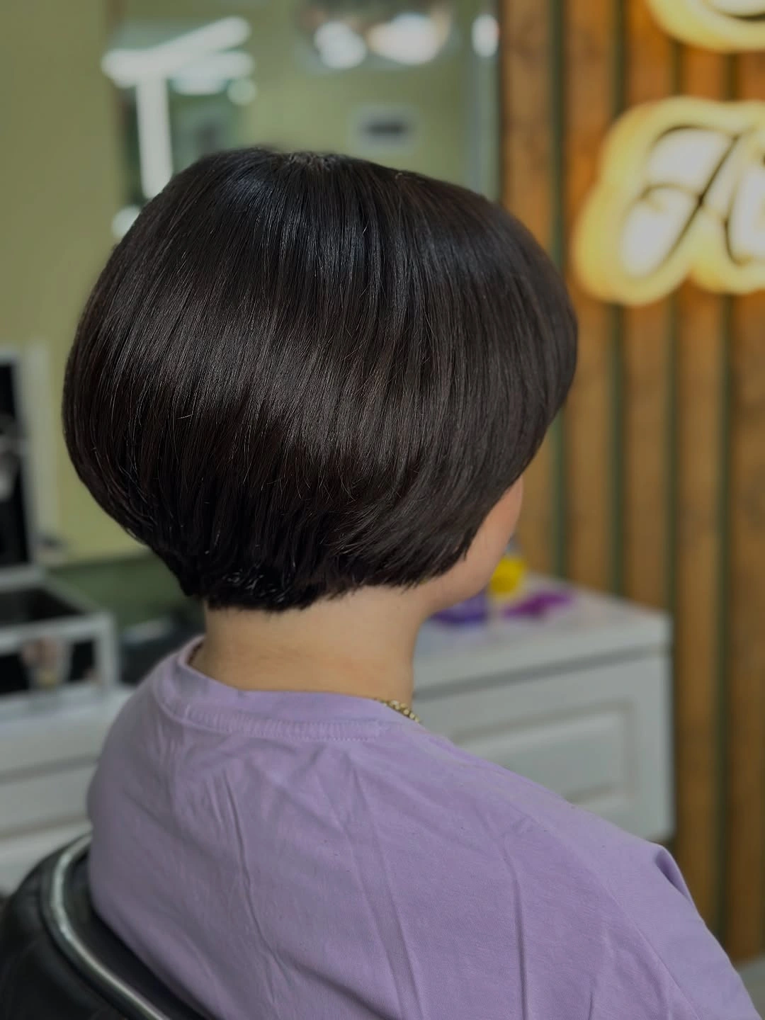 Rounded dark short bob with a cropped nape