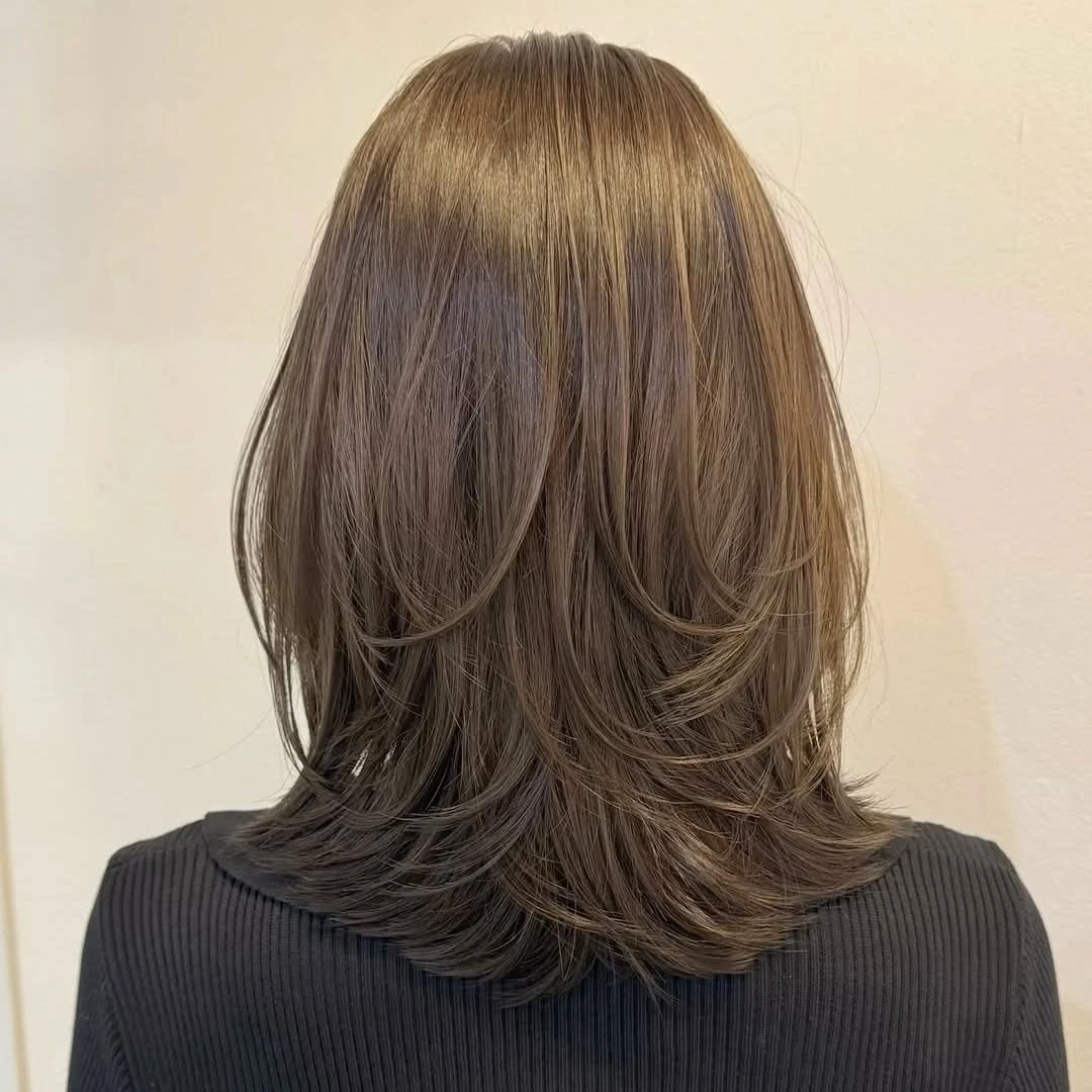 Shoulder length layered brown hair with flicked ends