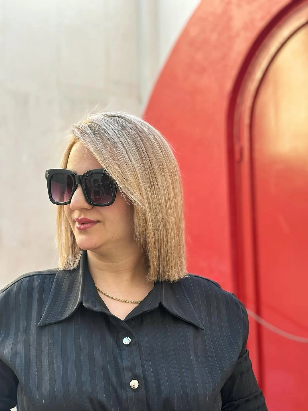 Short blonde blunt bob with sunglasses and dark shirt