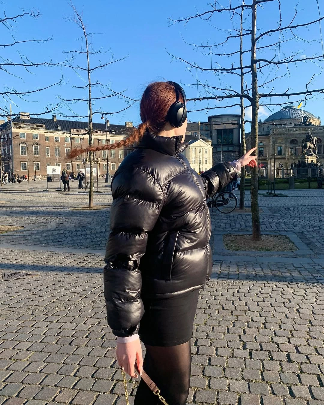 Glossy black cropped puffer with sheer tights and black earmuffs