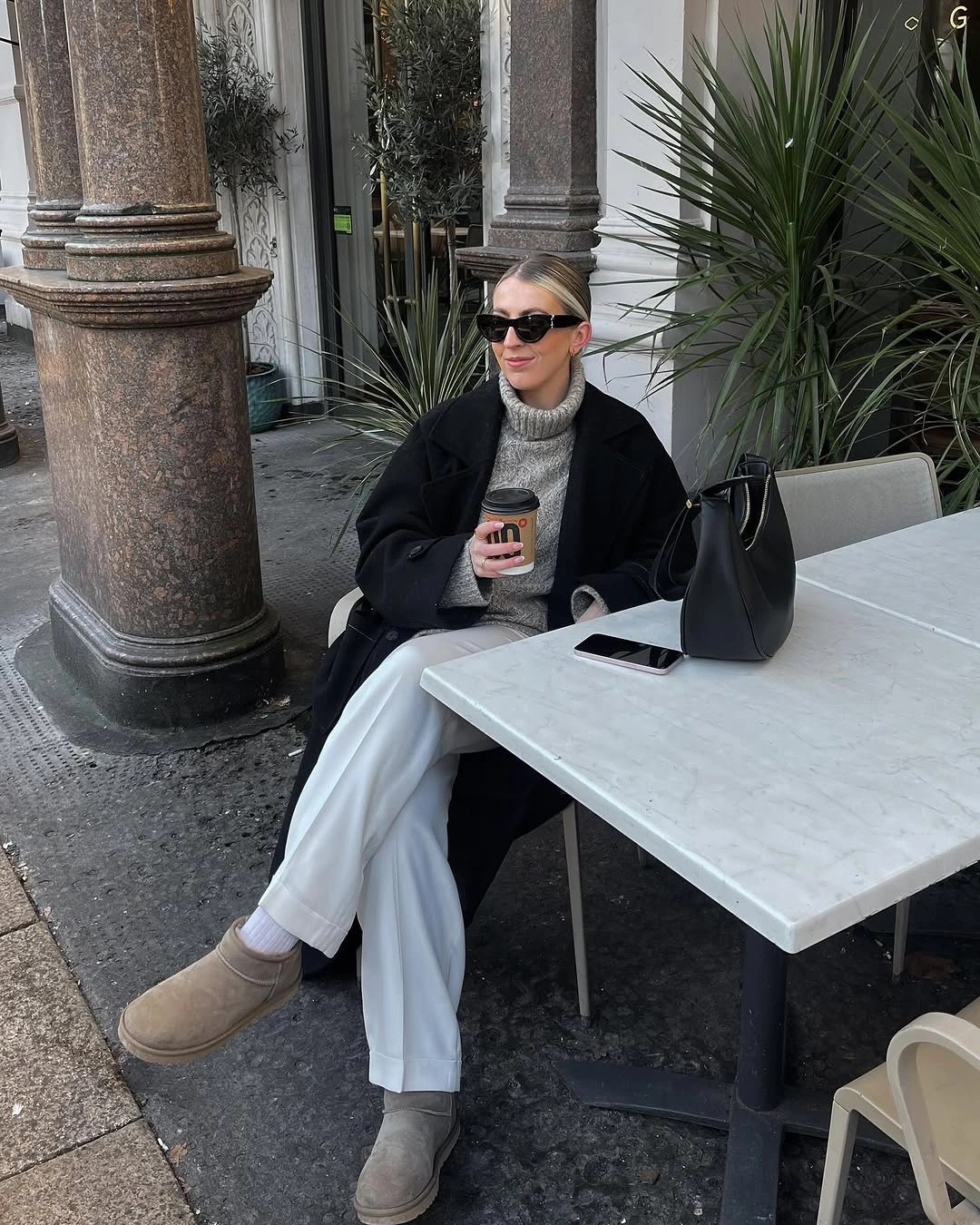 Black coat, gray turtleneck, white trousers, and taupe ankle boots