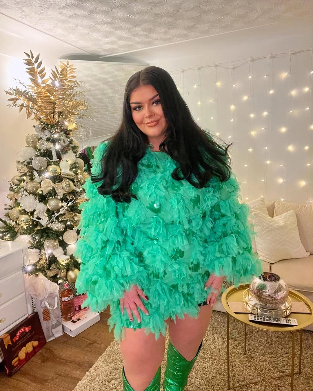 Woman in vivid green textured outfit and matching knee-high boots