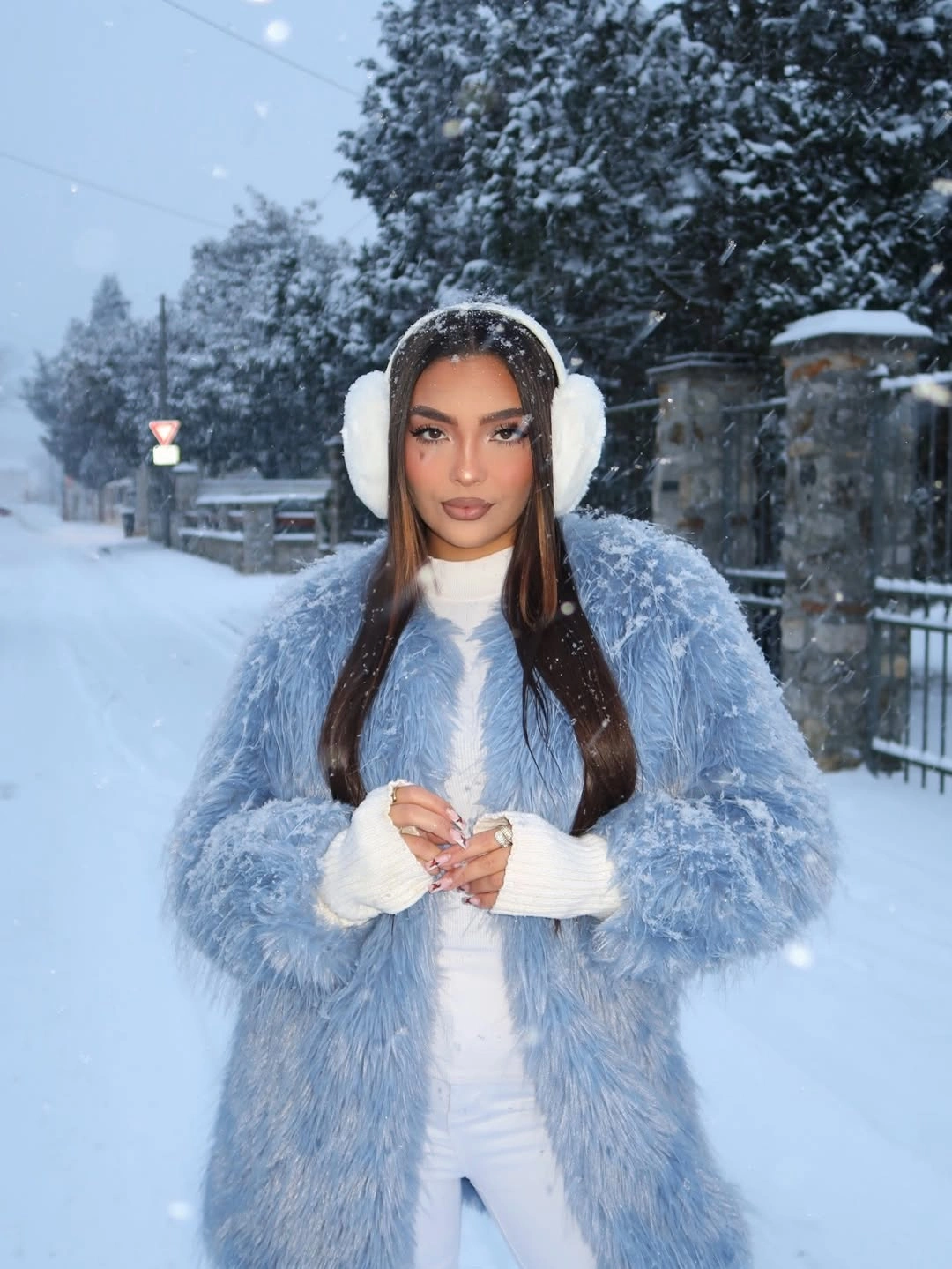 Icy-blue shaggy coat with white trousers, earmuffs, and hand coverings