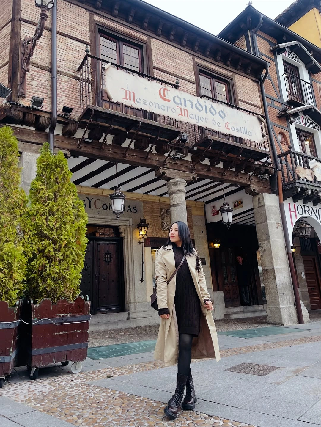 Long beige coat with black inner layer, tights, and tall boots