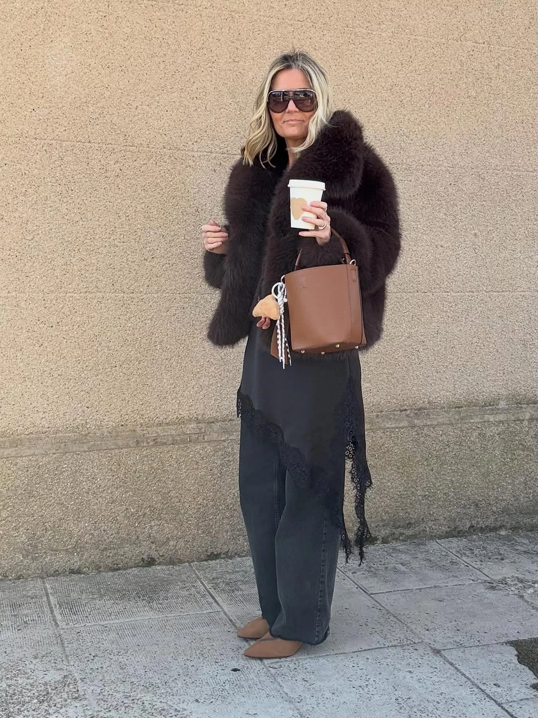 Dark-brown jacket, dark trousers, brown bag, and tan pointed shoes