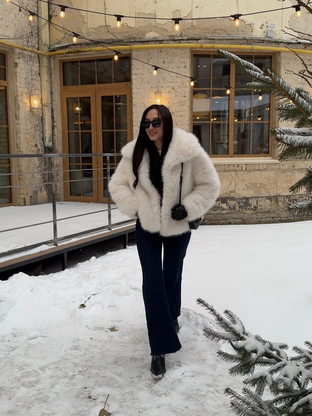 Ivory shaggy jacket, black trousers, sunglasses, and pointed black boots