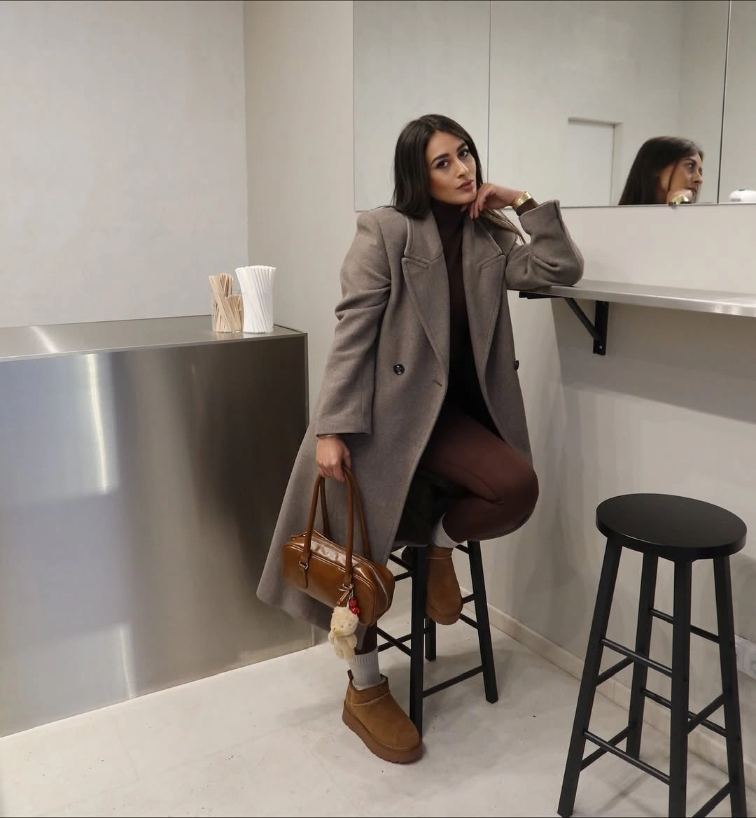 Taupe long coat, brown trousers, gray socks, and tan ankle boots