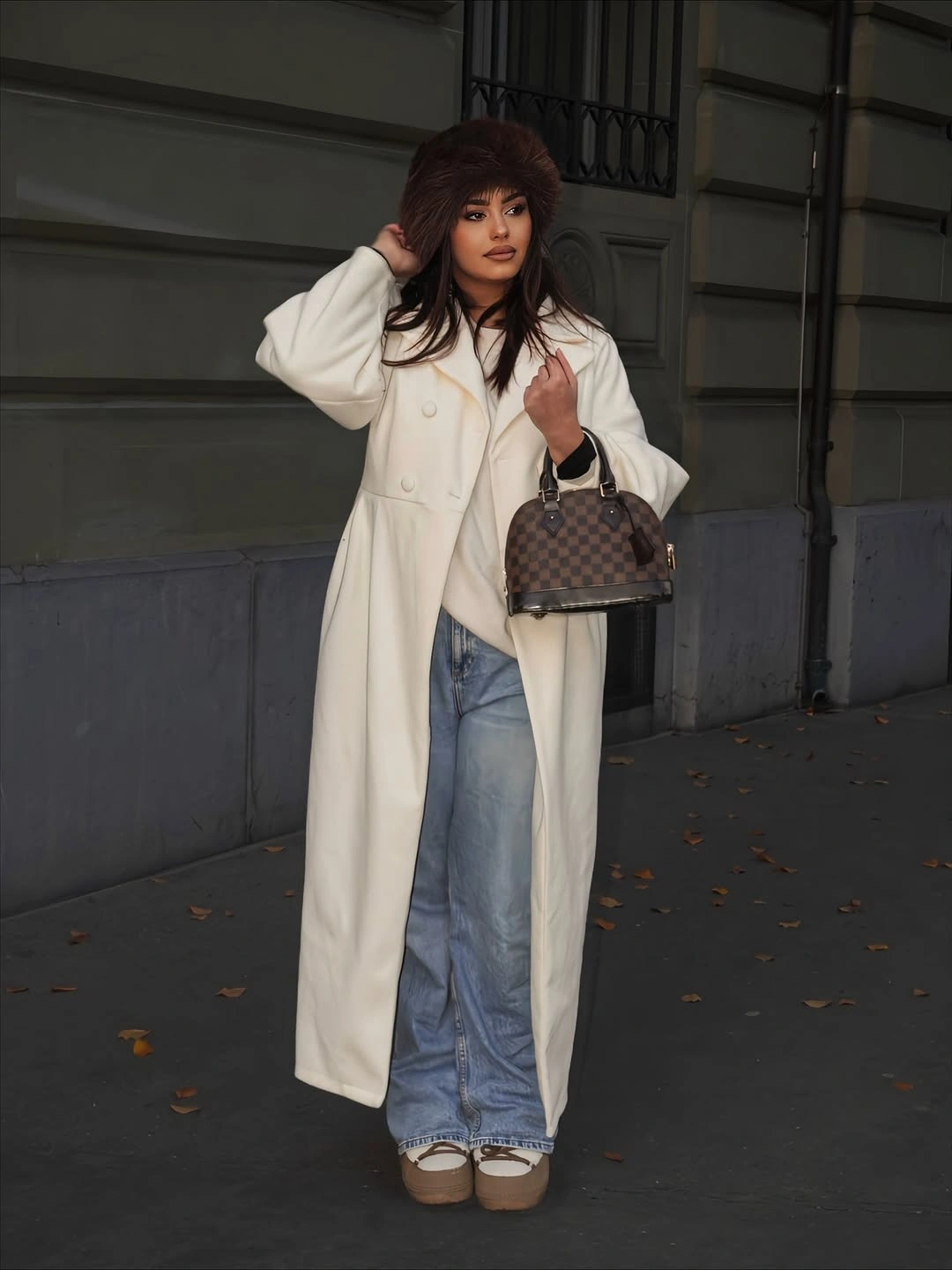 Cream long coat, wide blue jeans, fuzzy hat, and platform shoes