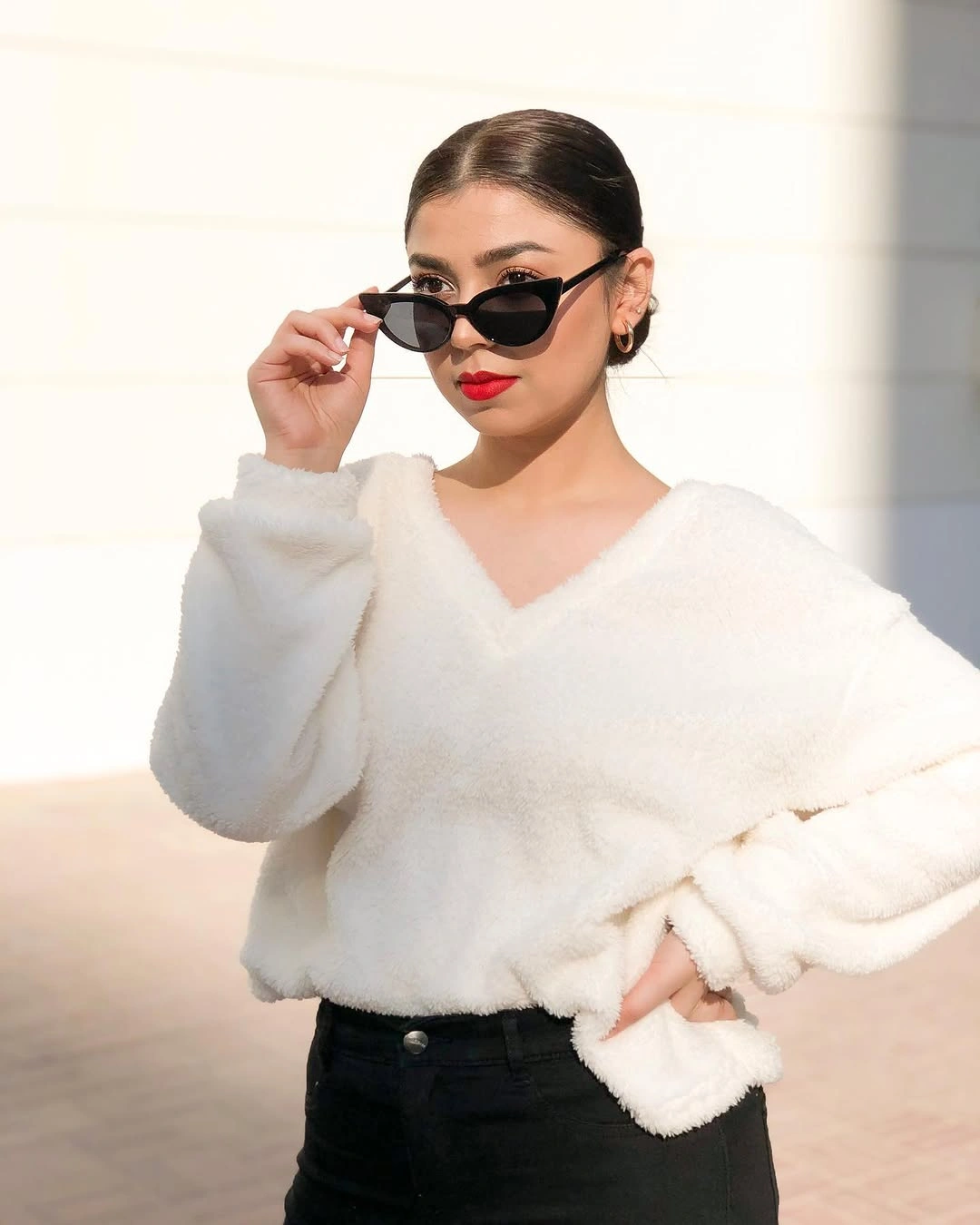 White fuzzy wrap top with black lower half and narrow sunglasses