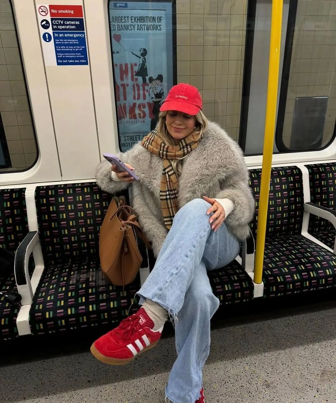 Gray textured jacket pale jeans red cap red sneakers and brown tote