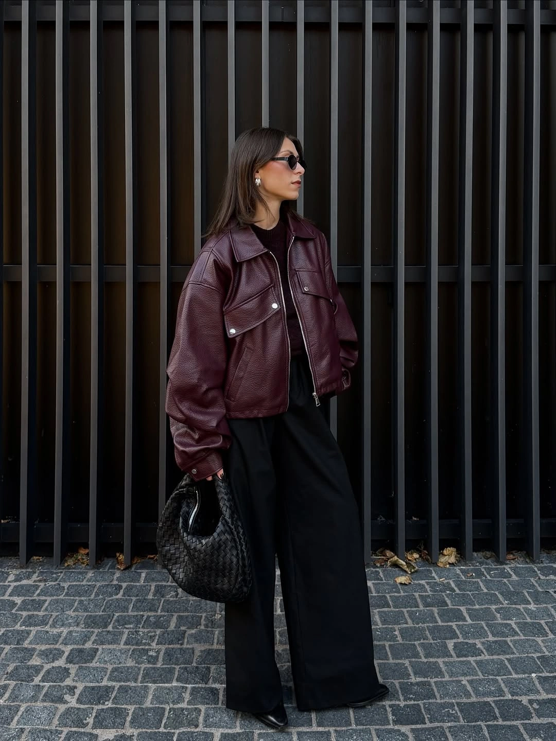 Burgundy structured jacket with black wide-leg trousers and black bag