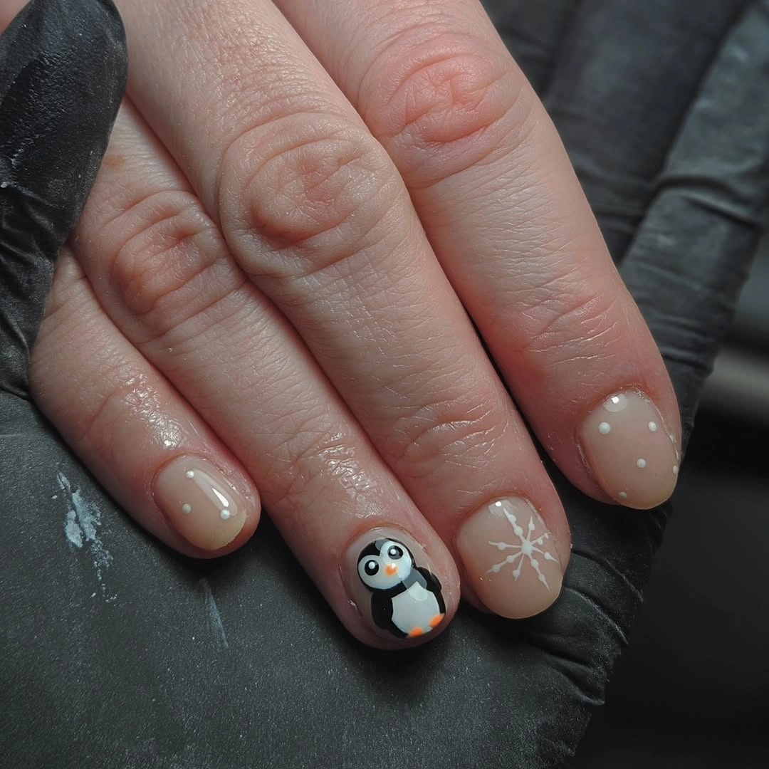 Very short nude nails with penguin, dots and snowflake