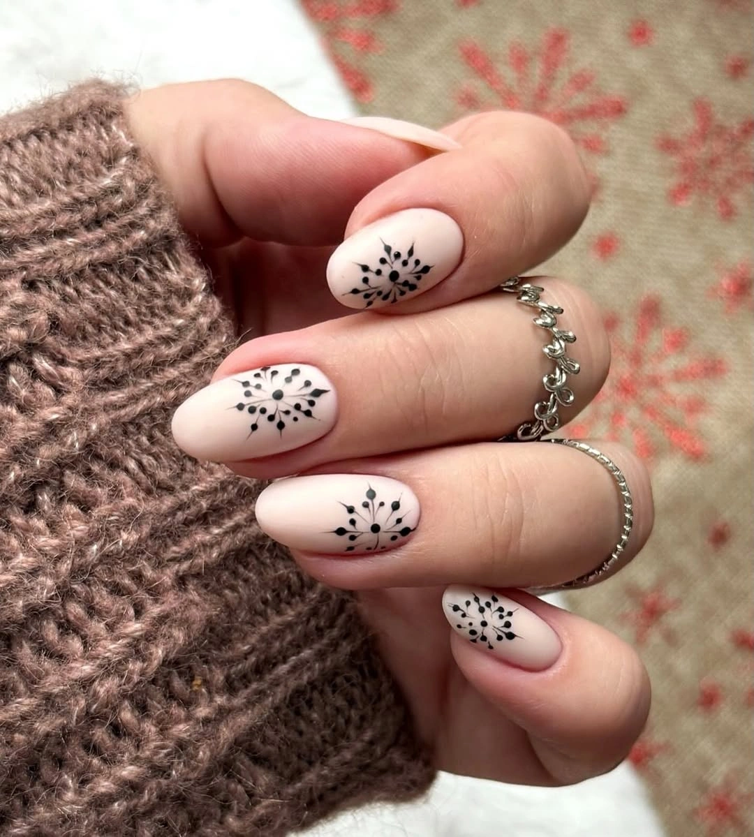 Short milky white nails with black dotted burst motifs