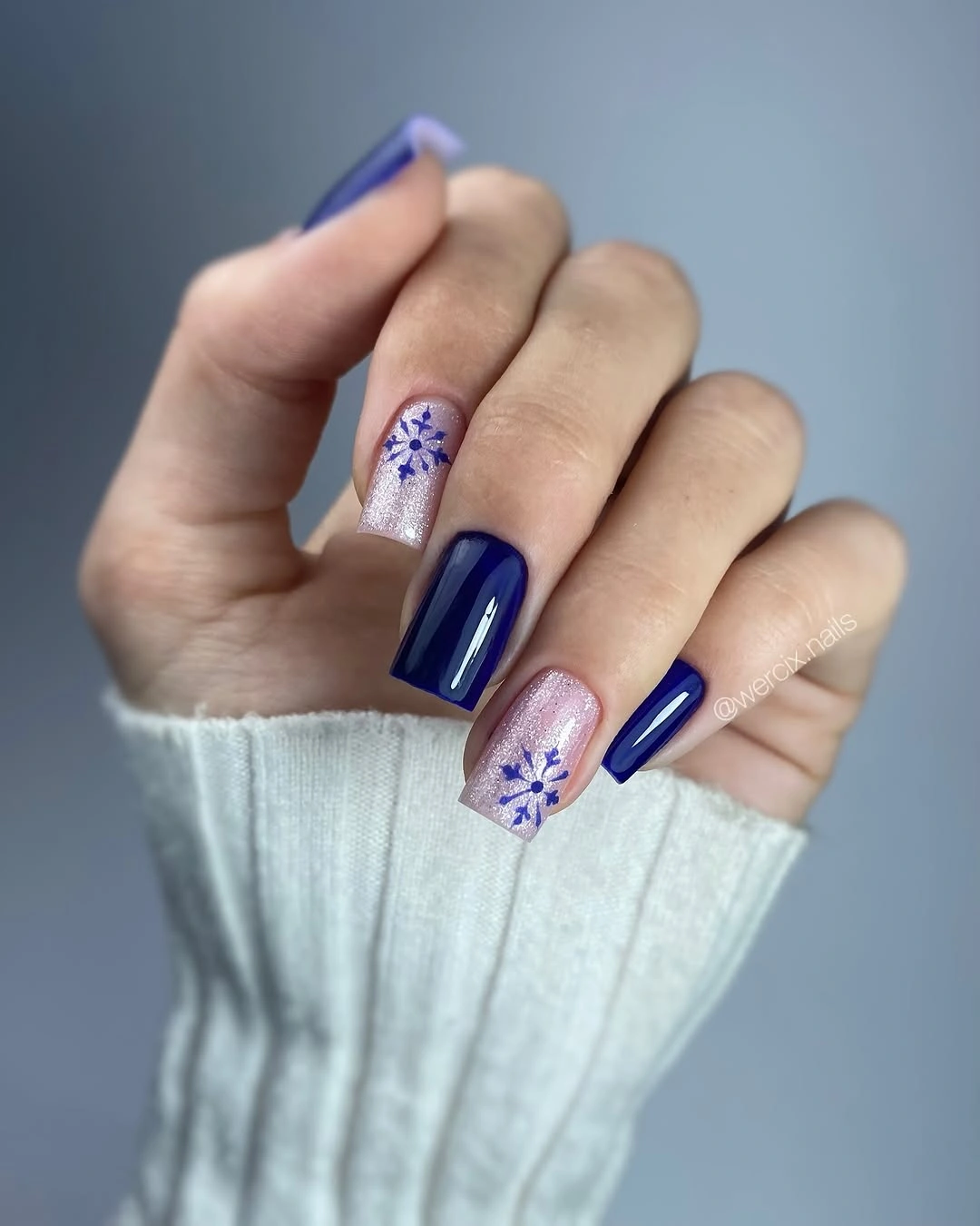 Medium square nails with navy polish and blue snowflakes