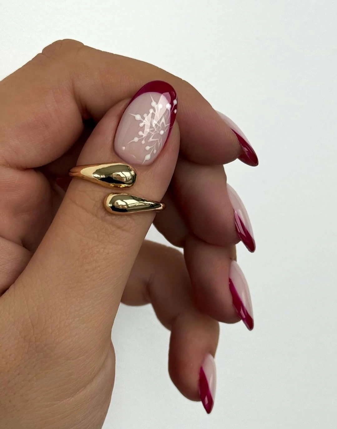 Long almond nails with red curved tips and snowflake
