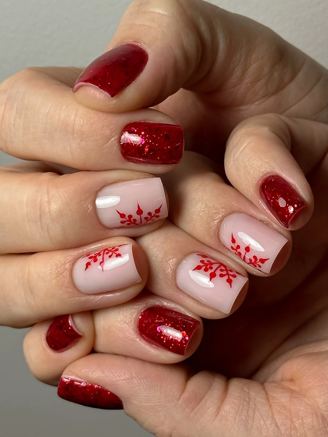 Short square red glitter nails with nude branch accents