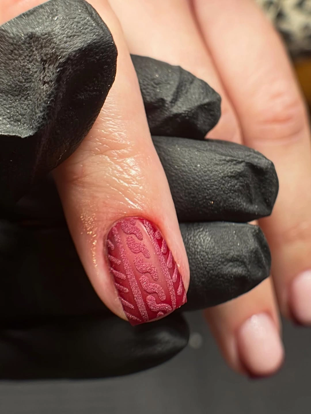Short red nail with raised cable knit texture