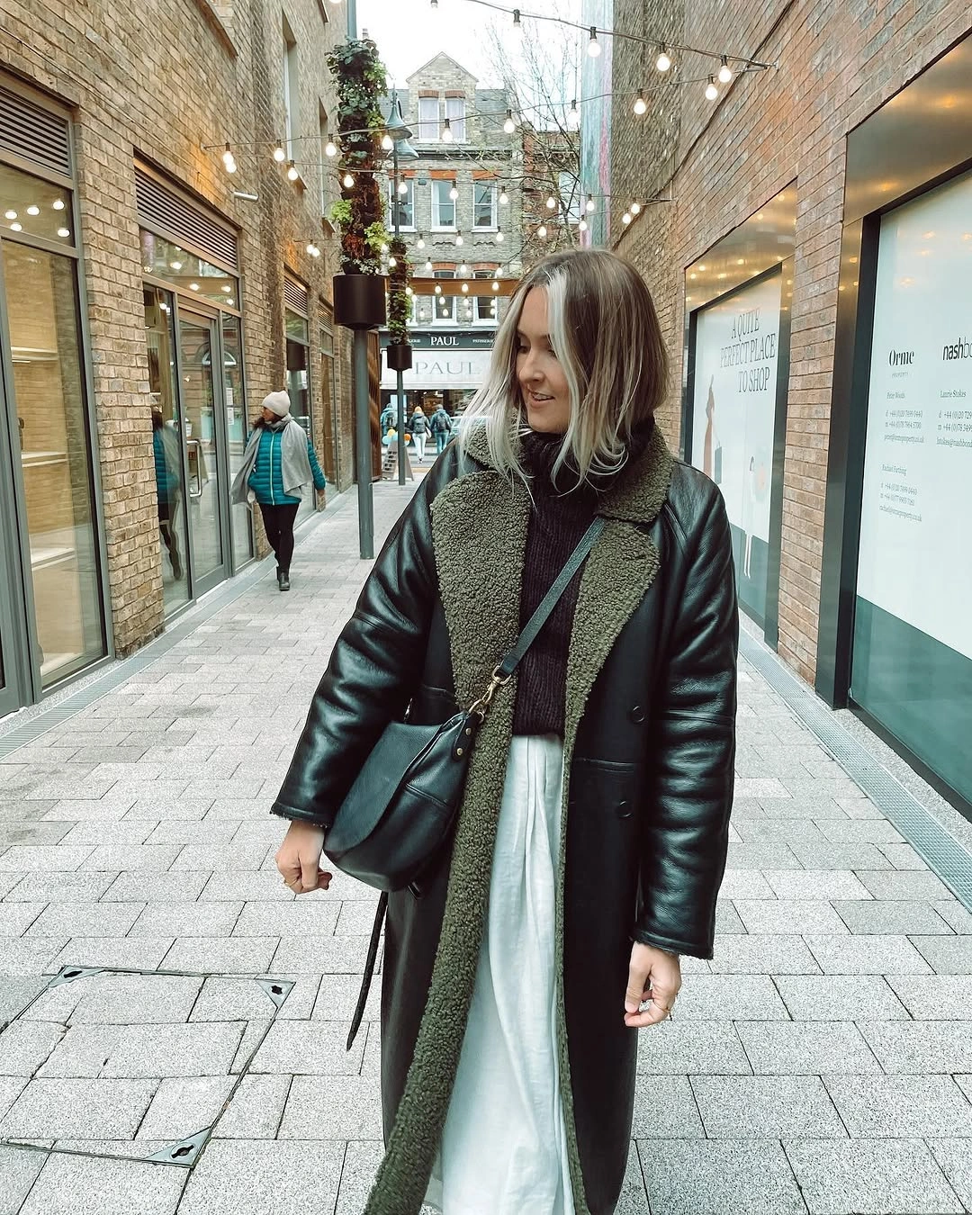 Dark coat with shearling-style lining and long white skirt