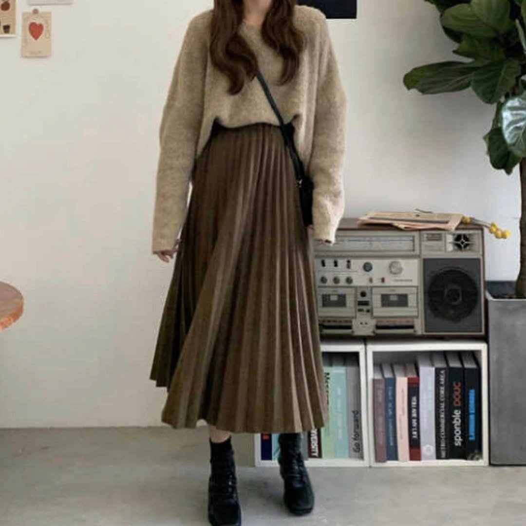 Beige sweater, long brown pleated skirt, black boots and crossbody strap