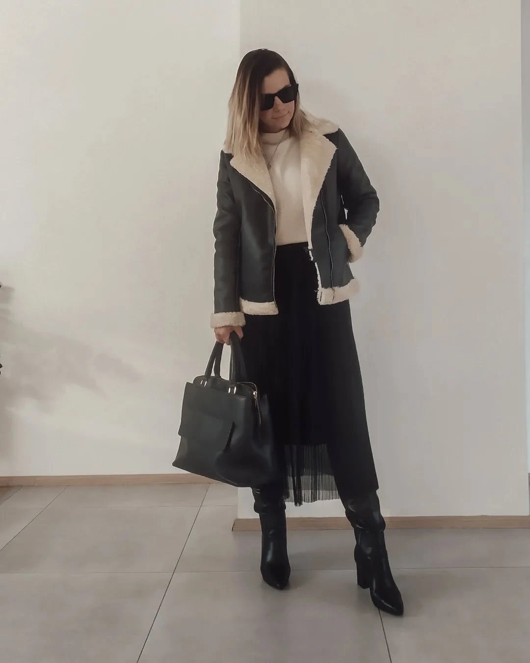 Dark jacket, cream collar, sheer black skirt layer and boots