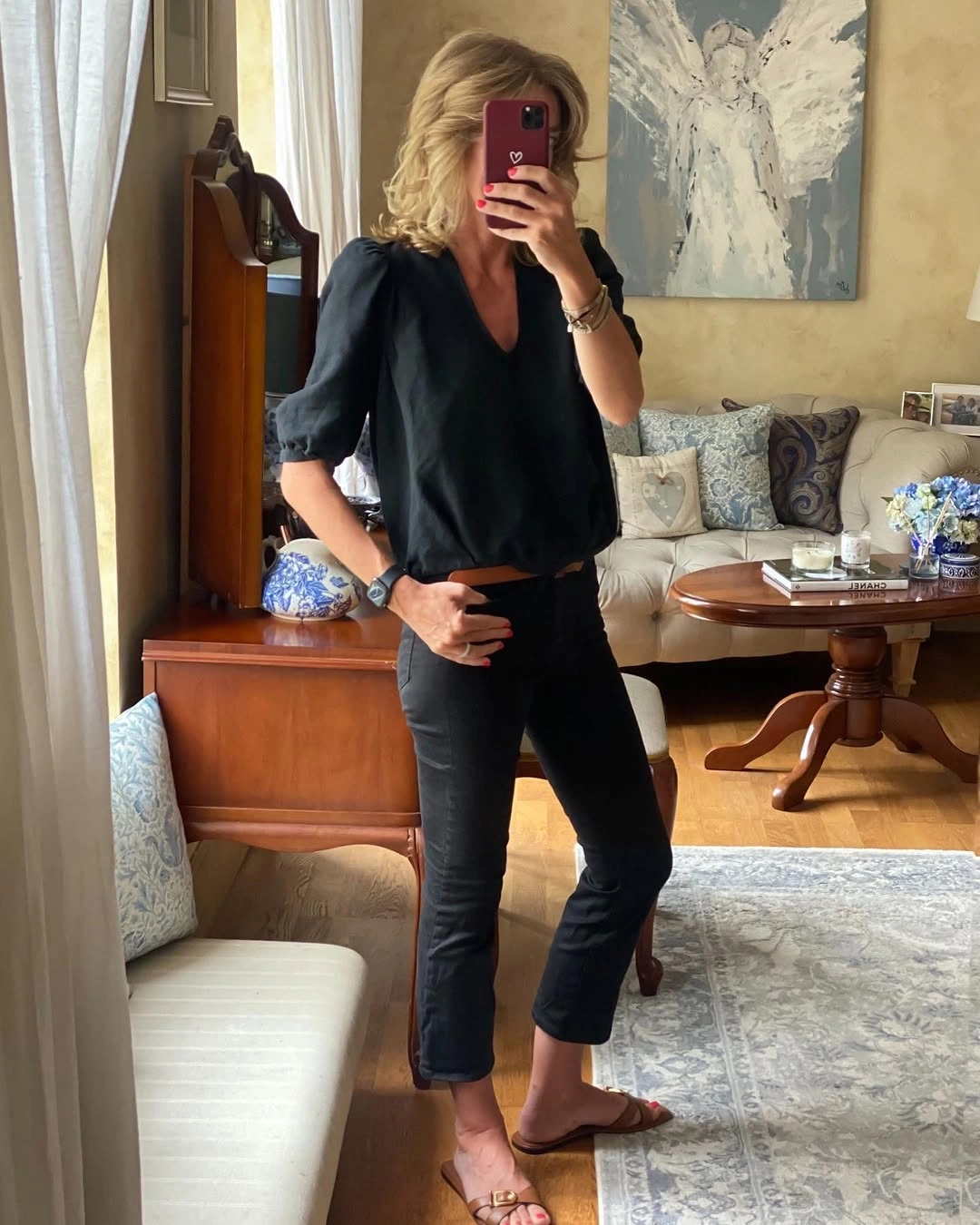 Black V-neck blouse with cropped black bottoms and tan sandals