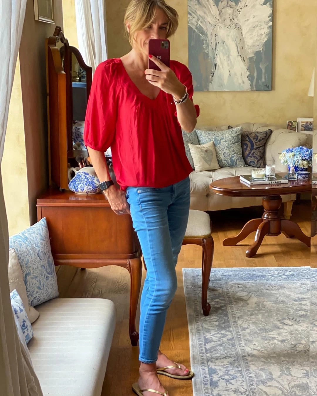 Red V-neck blouse with light jeans and metallic flat sandals