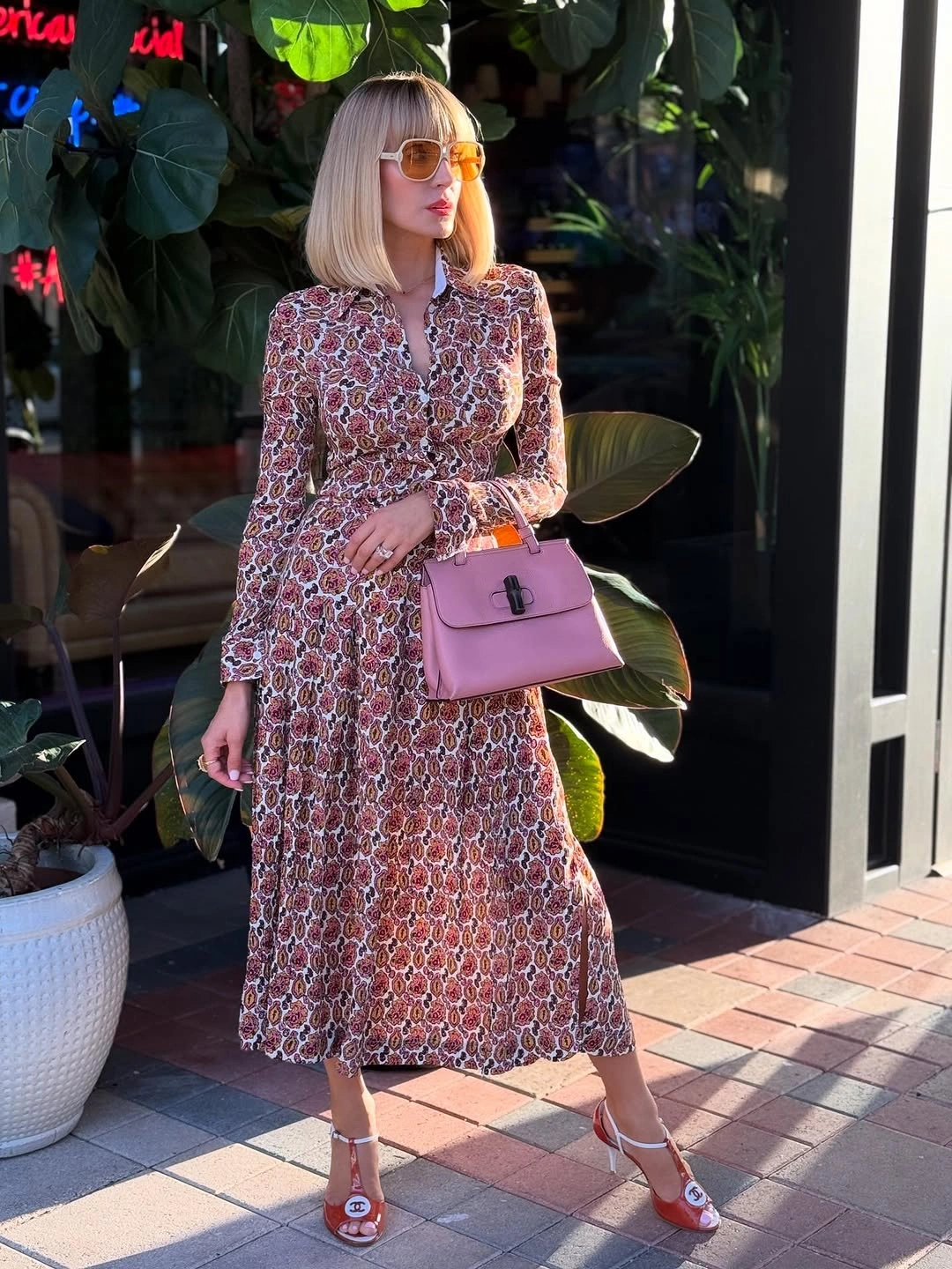 Printed midi dress with pink bag orange sunglasses and heeled sandals