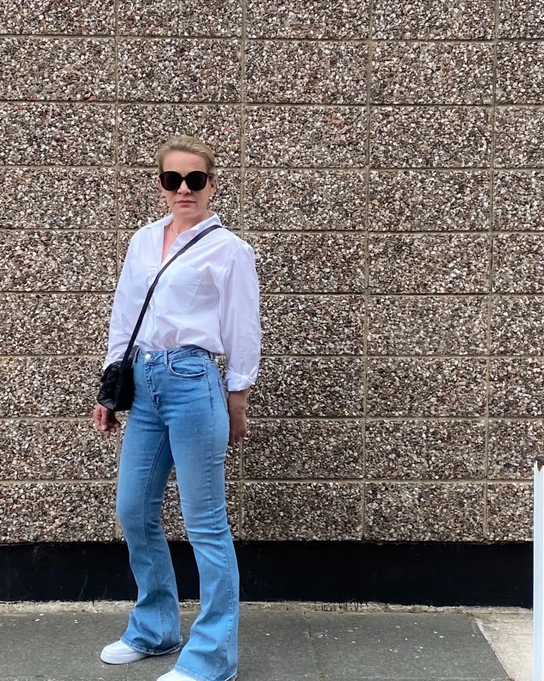 Tucked white shirt with light jeans and black crossbody bag