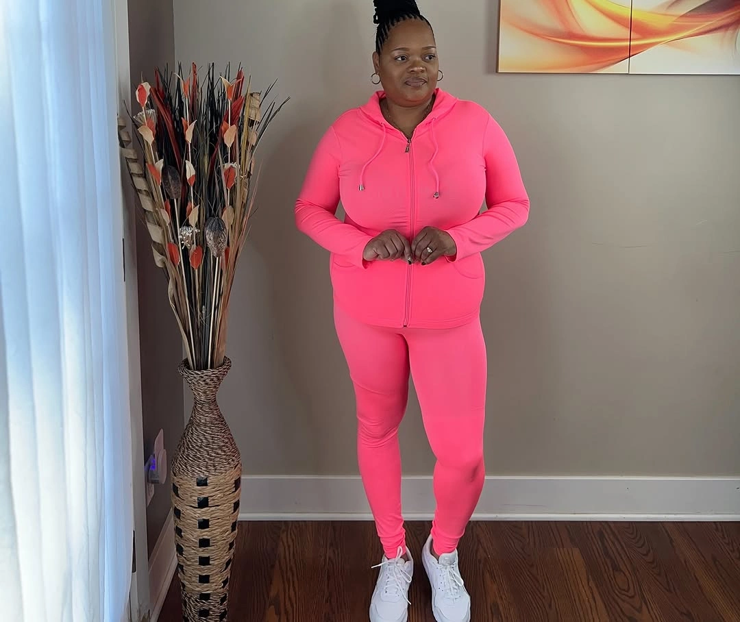 Bright pink zip hoodie with matching leggings and white sneakers