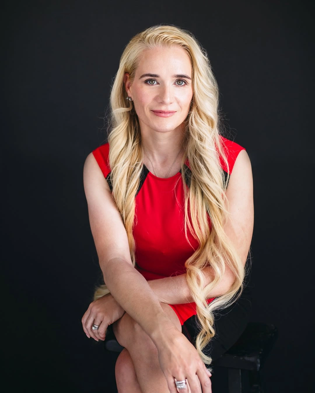 Red sleeveless top with black lower piece against dark background