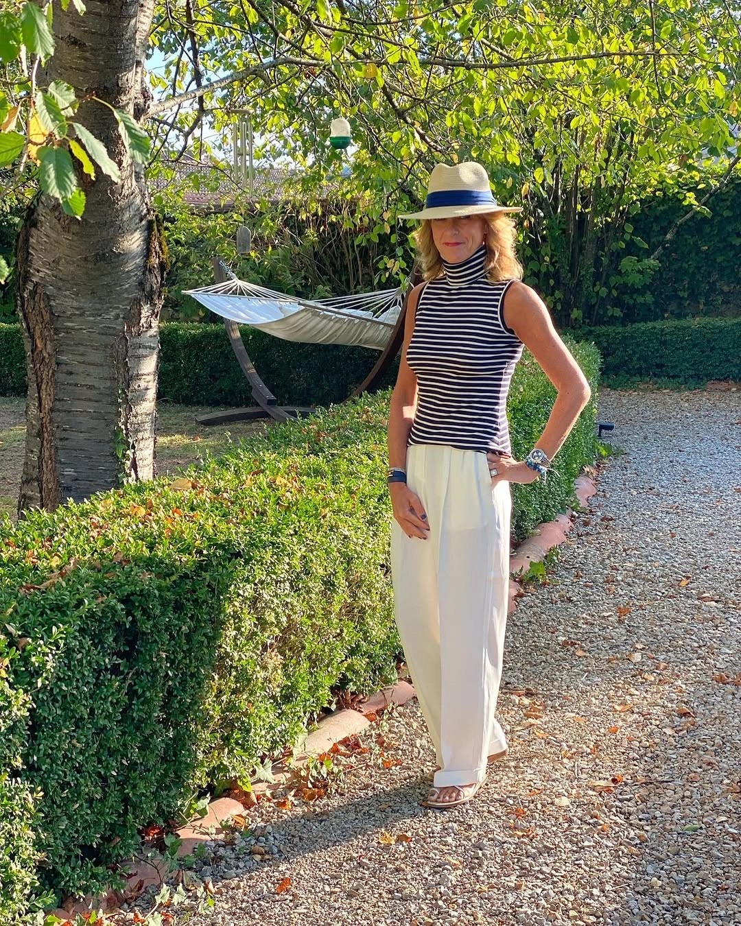 Striped sleeveless top with light wide-leg trousers and brimmed hat