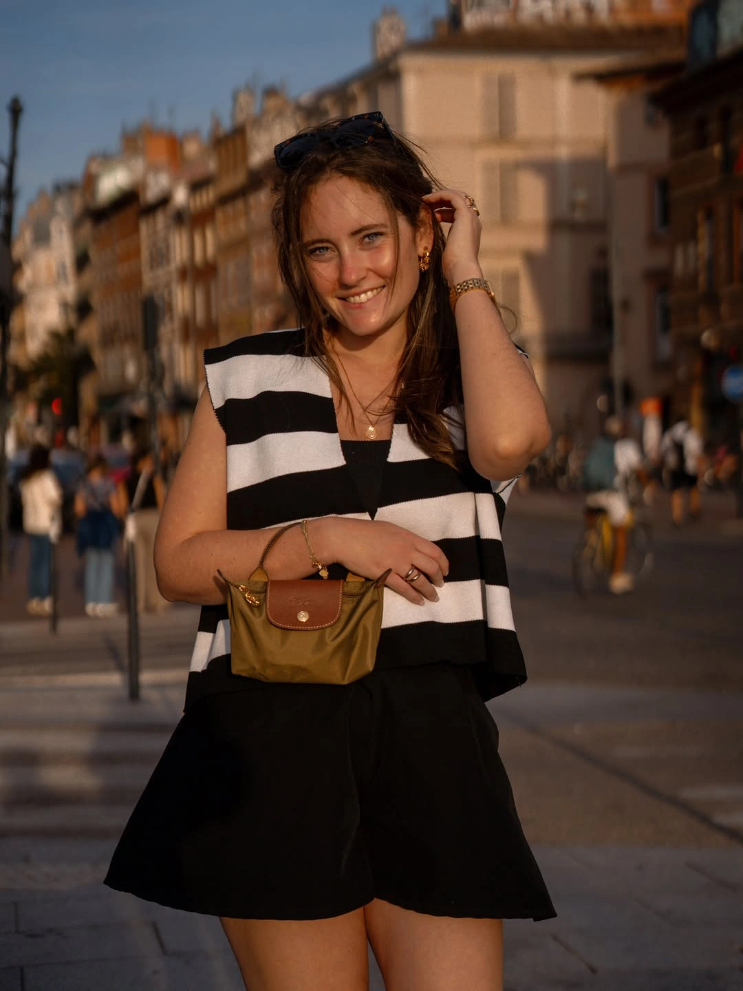 Sleeveless black and white striped top with black shorts and small brown bag