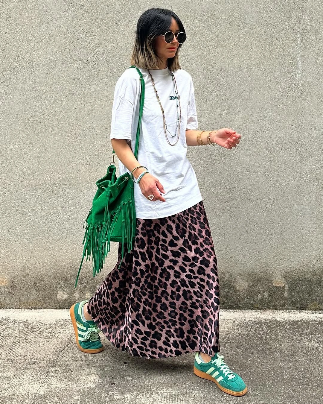 Oversized white T-shirt with leopard-print maxi skirt, green sneakers and fringed bag