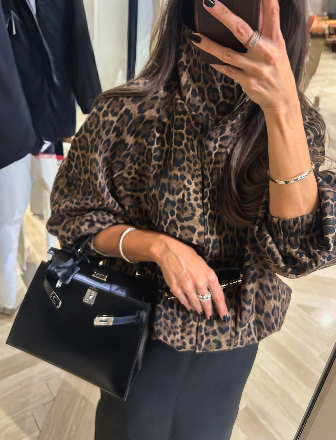 Brown leopard-print high-neck blouse with black bottoms and structured handbag