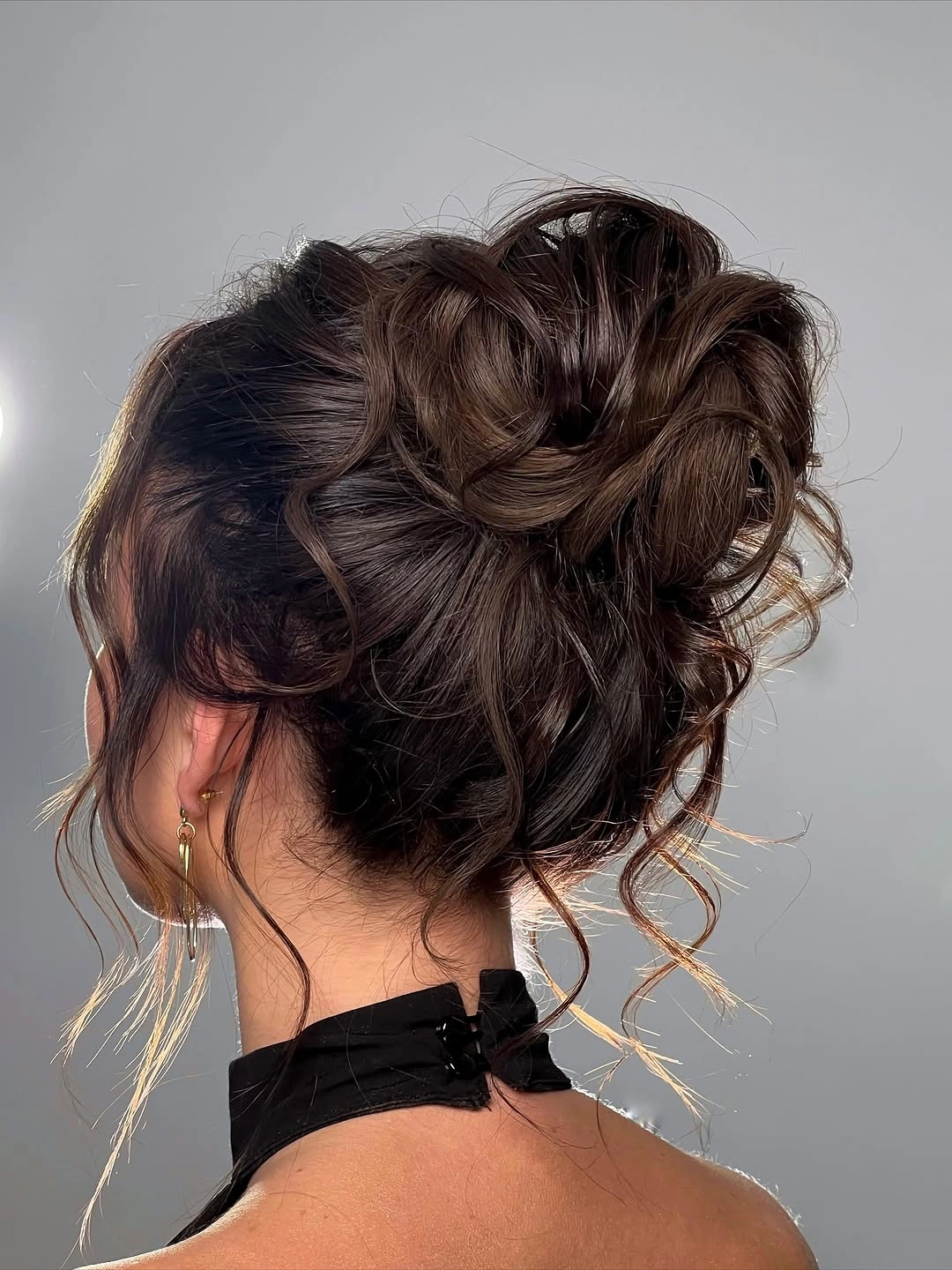 Brunette textured updo with large loops and loose tendrils