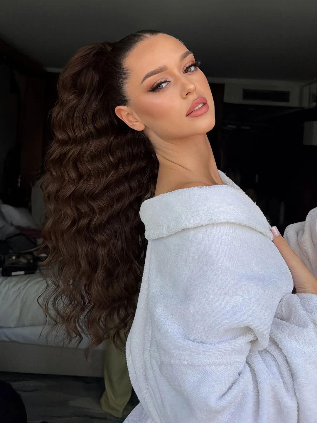 Very long dark brown high ponytail with dense repeating waves