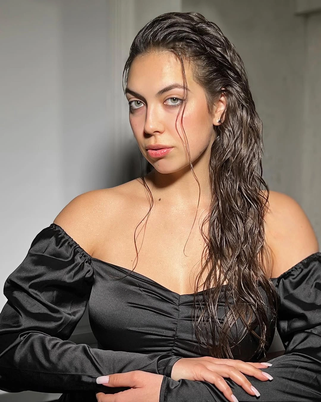 Glossy dark hair swept back with wet-look textured lengths