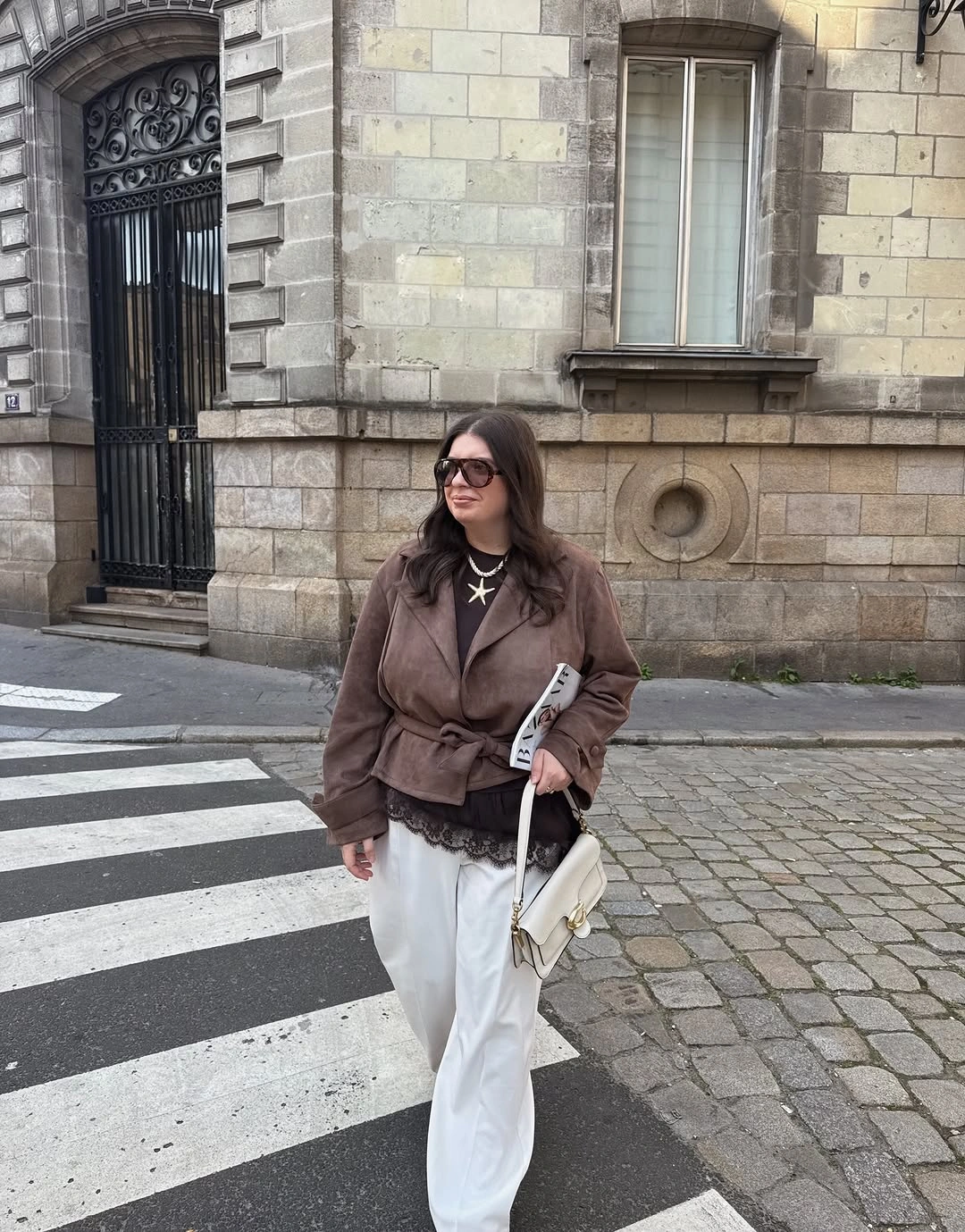 Brown gathered waist jacket with off white trousers and pale shoulder bag