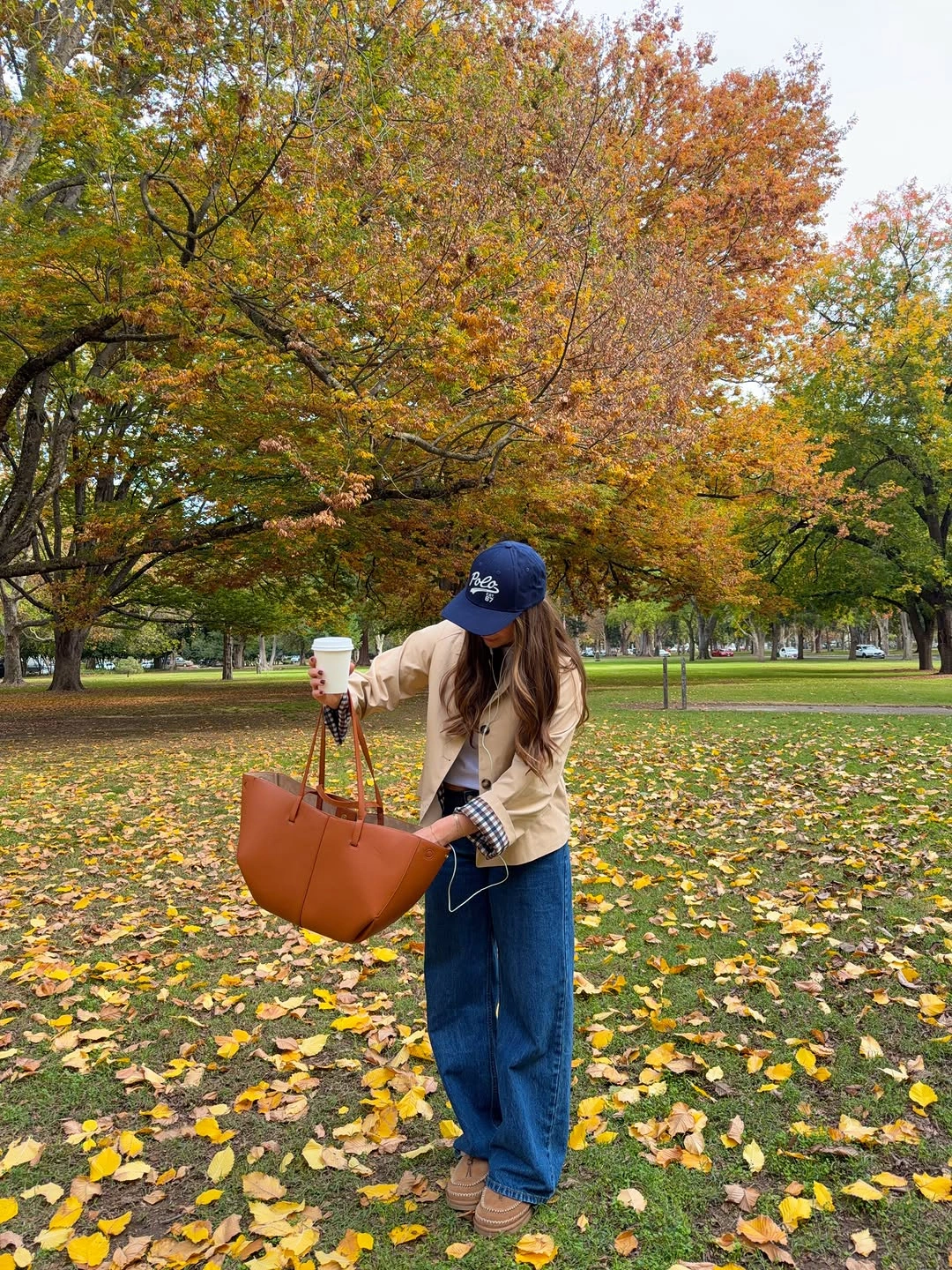 Beige jacket wide blue jeans checked cuffs and tan tote