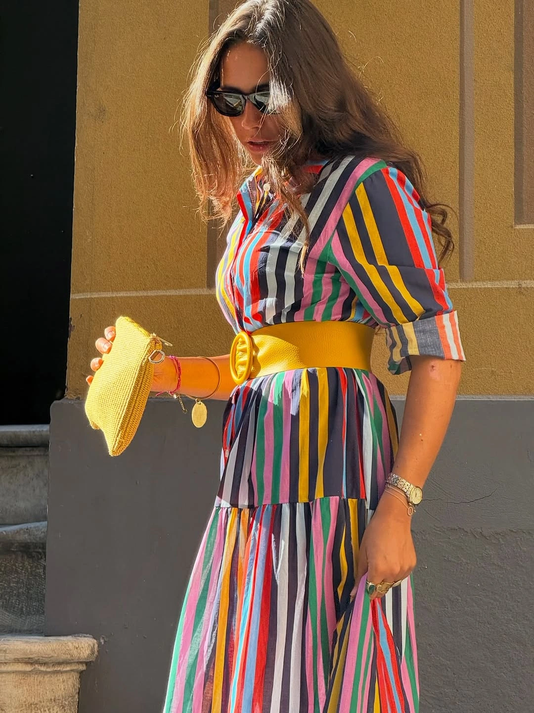 Multicolor striped dress with yellow belt and clutch