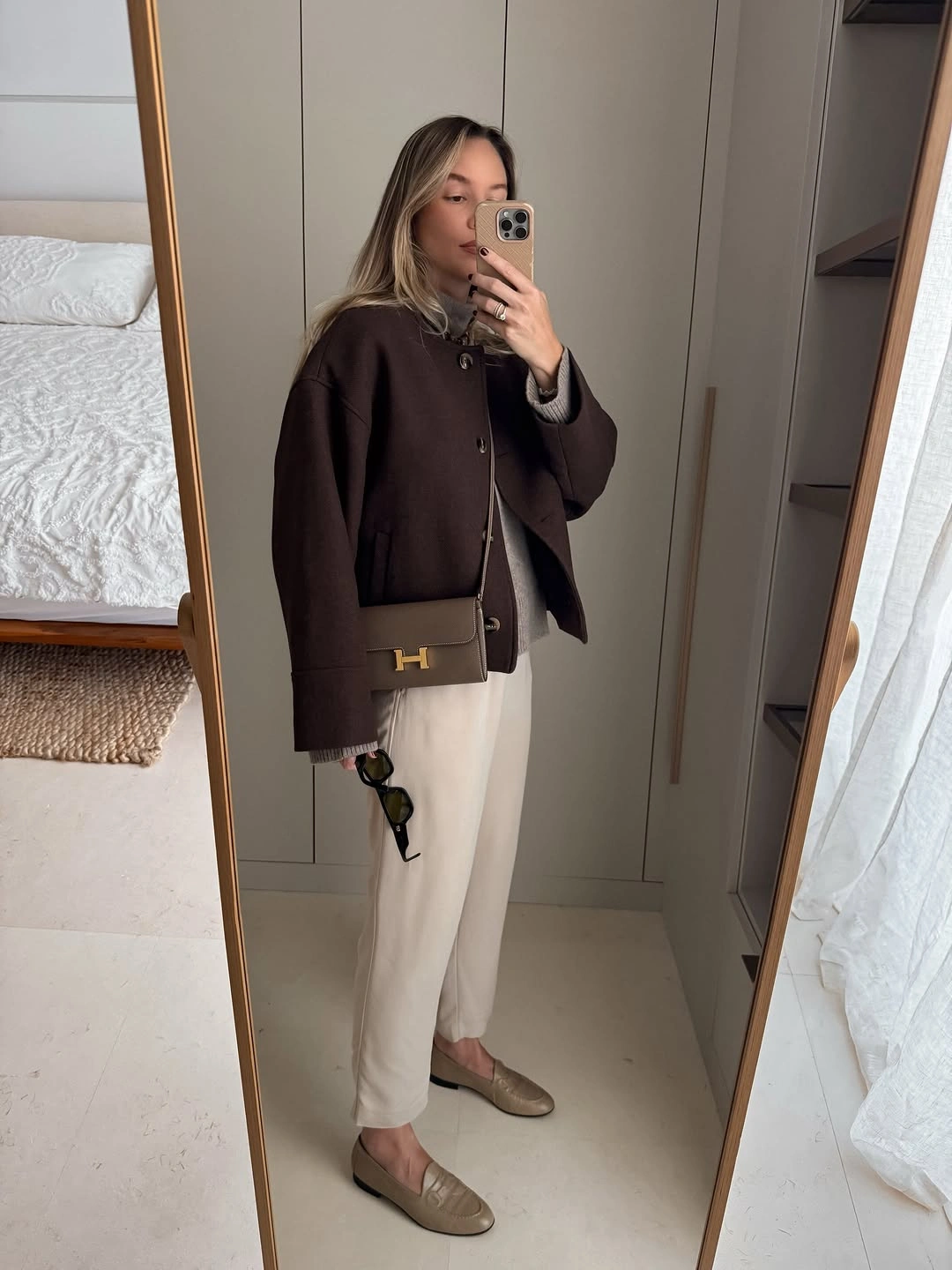 Dark brown jacket cream trousers taupe loafers and brown bag